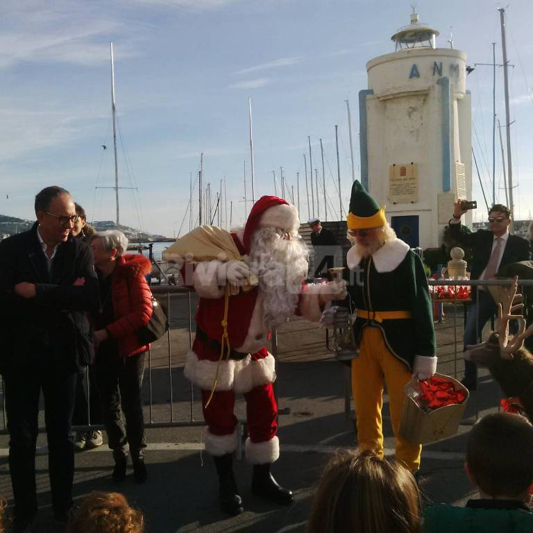 A Sanremo Babbo Natale arriva dal mare e ad accoglierlo trova il vescovo Suetta