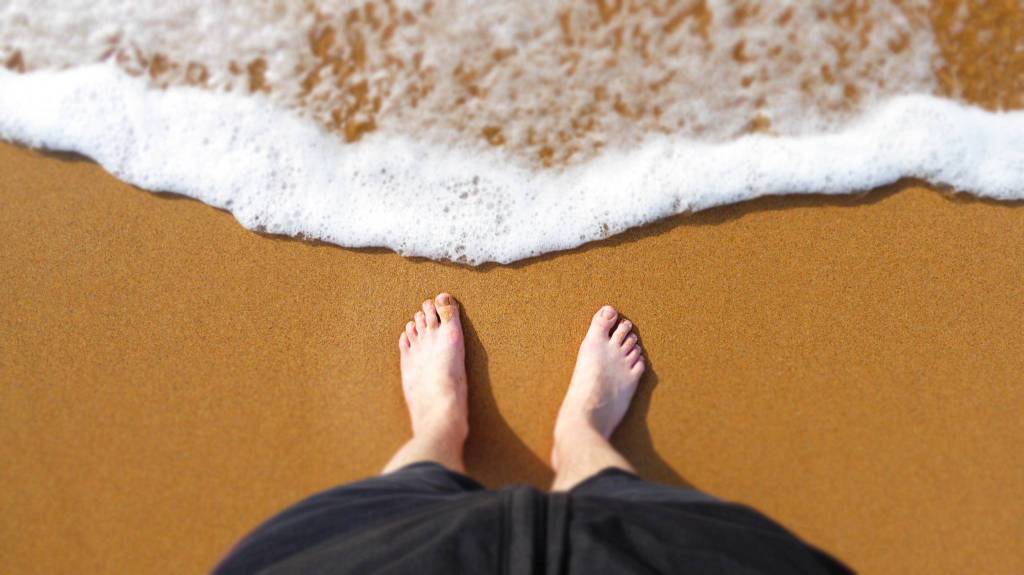 L’estate è alle porte: camminare a piedi nudi in spiaggia fa bene? I consigli e le raccomandazioni del podologo