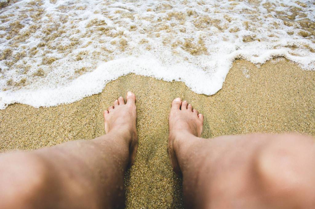 L’estate è alle porte: camminare a piedi nudi in spiaggia fa bene? I consigli e le raccomandazioni del podologo